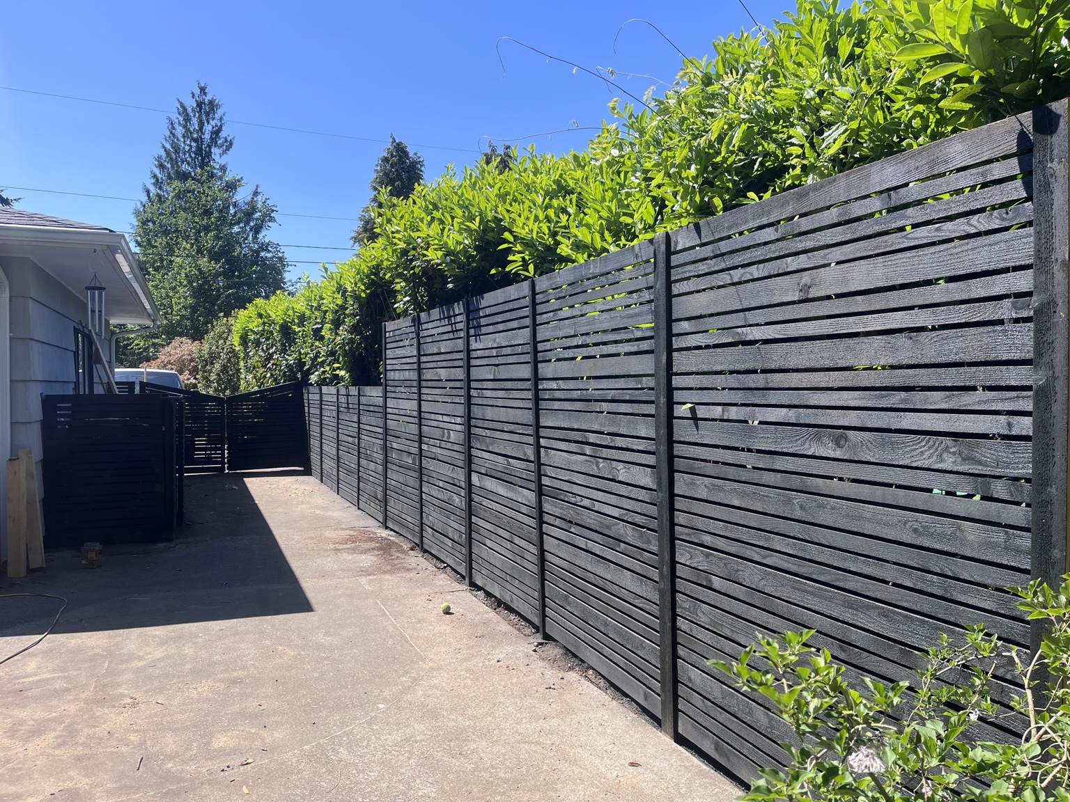 Custom black horizontal wood fence by ContractHer Home Solutions